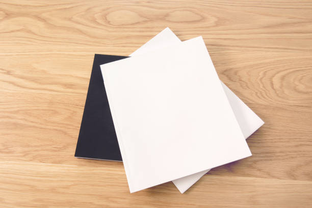 istock Blank white stacking magazine cover on wooden table background. 939485498