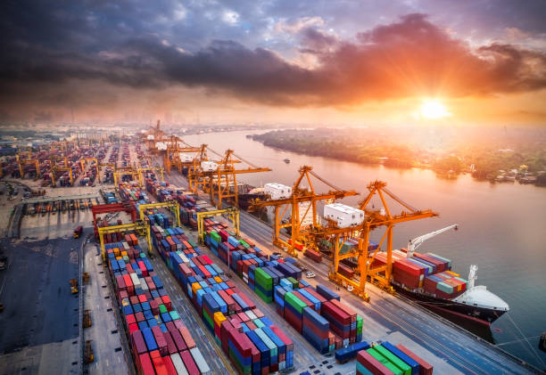 istock Logistics and transportation of Container Cargo ship and Cargo plane with working crane bridge in shipyard at sunrise, logistic import export and transport industry background 939493862