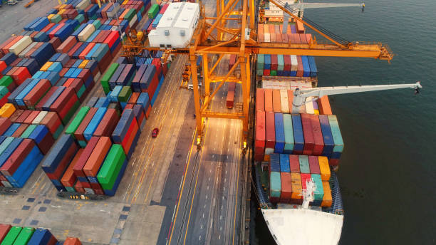 istock Logistics and transportation of Container Cargo ship and Cargo plane with working crane bridge in shipyard at sunrise, logistic import export and transport industry background 939493868