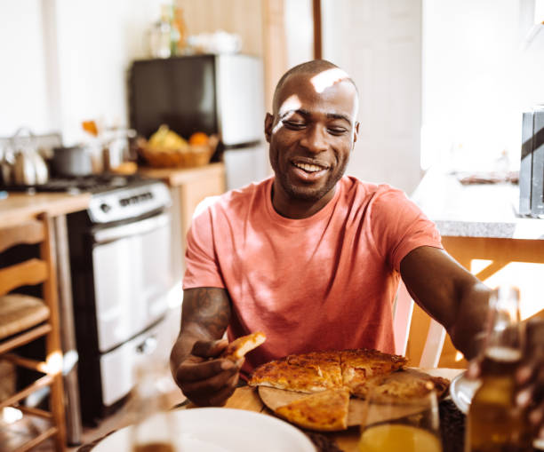 istock man eating a pizza in the kitchen 939497356