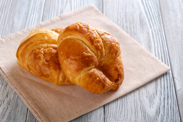 istock Croissants on a wooden table. 939497516
