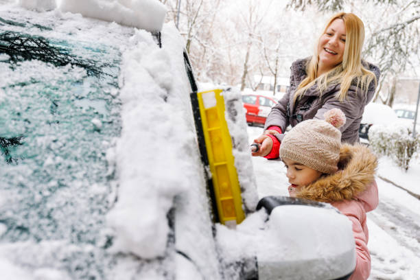 istock Family removing snow from their car together 939497766