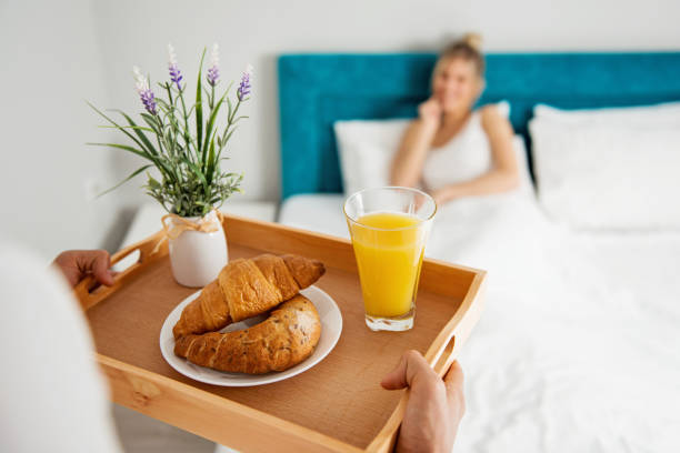 istock Man bringing breakfast to his girlfriend in bed 939498670