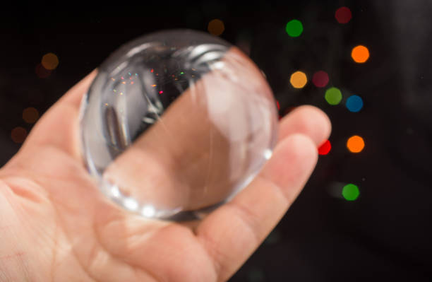 istock Half a glass sphere in hand with bokeh lights behind 939499016