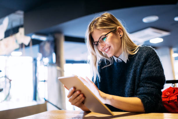 Portrait of young attractive woman using tablet Portrait of young attractive woman using digital tablet cafe tablet stock pictures, royalty-free photos & images