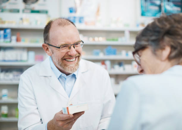 istock Smiling male pharmacist serving elderly female customer 939502528