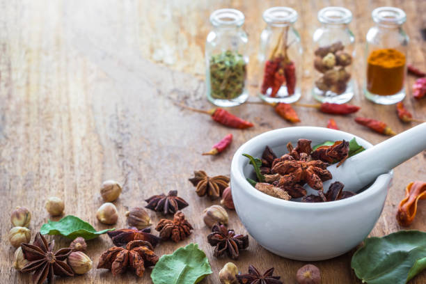 mortar grinder and herb medicine on wood table - cardamom cinnamon mortar and pestle herb imagens e fotografias de stock