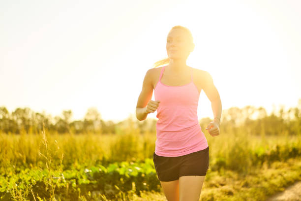 istock young woman jogging in bright sunshine 939502620