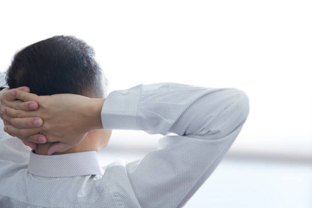 Rear view of businessman in white shirt in relaxing posture at the end of the day after a hard work finished with right copy space. Clipping path included.