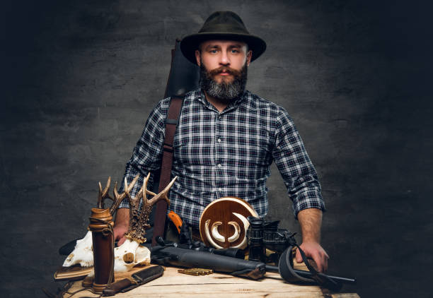 istock Bearded traditional hunter with his trophy holds a rifle. 939515310