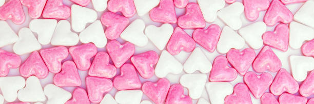 istock sweet sugar hearts colored white and pink, panorama background 939515870