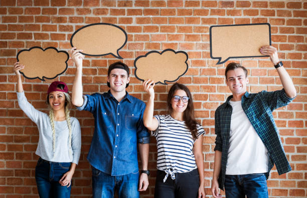 istock Happy young adults holding up copy space placard thought bubbles 939518720