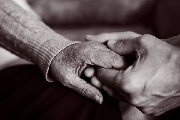 giovane che tiene la mano di una vecchia - old hands foto e immagini stock