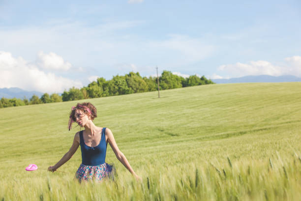 Woman with long tousled hair next to the wind turbine with the wind blowing