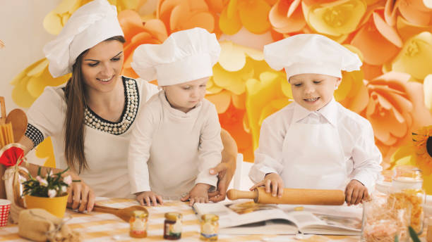 istock happy mother with children preparing dinner in the kitchen 939529596