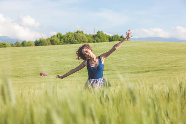 istock Beautiful woman dreaming with lollipop in the spring fields 939529812