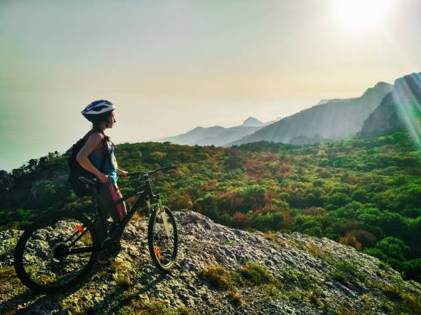 istock Young active woman with bicycle standing on mountain 939533002