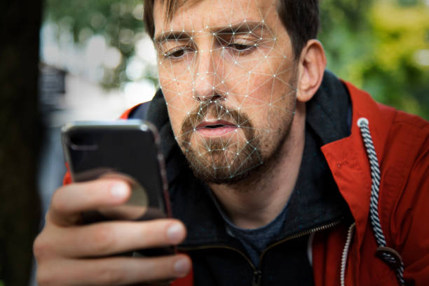 istock Young Man Unlocking his Smartphone with Facial Recognition Scanner 939533888