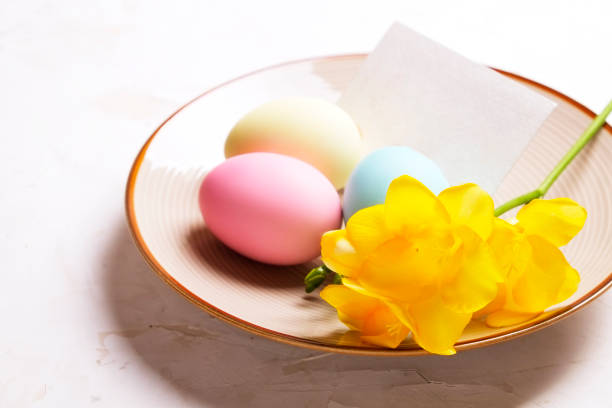 istock Different pastel color Easter eggs laid and arranged in beautiful composition with white wildflowers. Greeting card with copy text space. 939538590