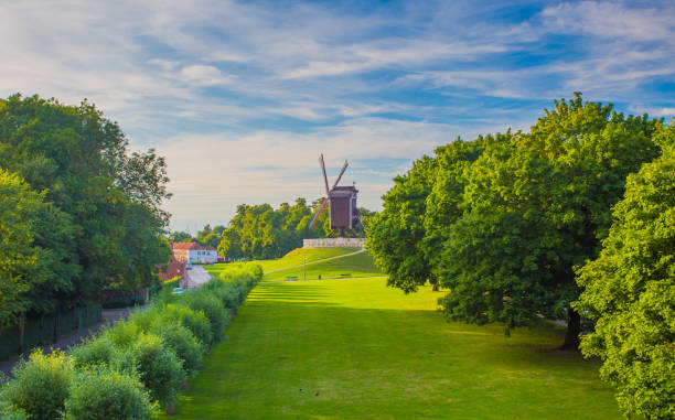 This beautiful Mountain mill is located in Anzegem Belgium, with the rise of the sun and  cloudy