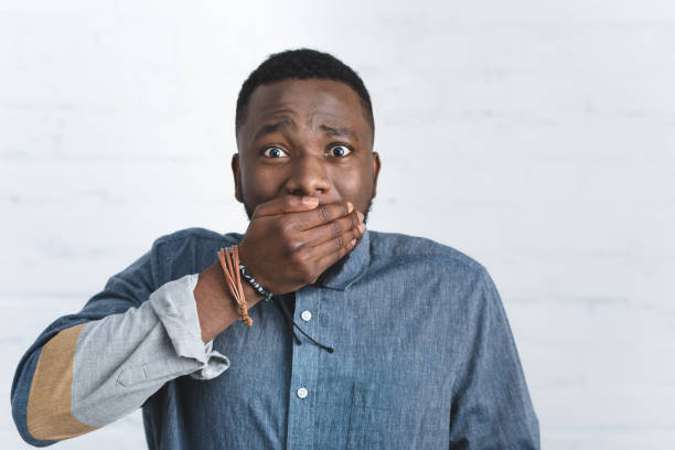 istock Young shocked man covering his mouth with hand 939542162