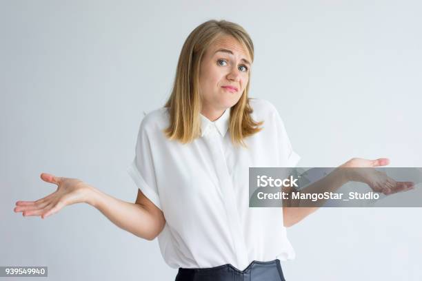 Confused Female Student Shrugging Shoulders Stock Photo - Download Image Now - Confusion, Women, One Woman Only