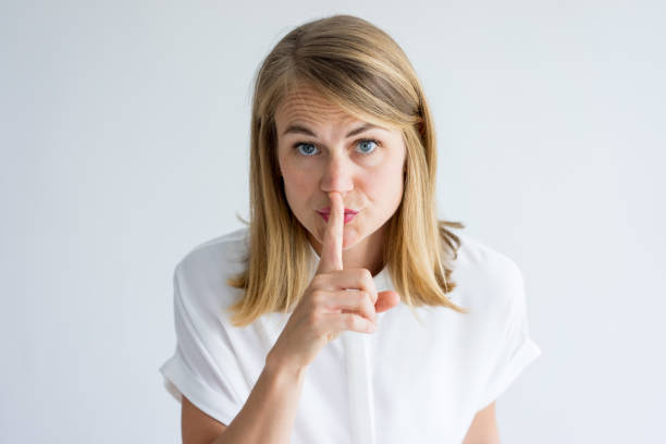 porträt der selbstbewusste frau mit finger auf die lippen - silence finger on lips businesswoman one person stock-fotos und bilder