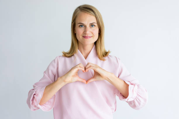 istock Smiling peace-loving lady showing heart 939553454