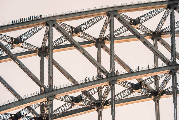 touristen klettern auf zwei ebenen der sydney harbour bridge - sydney harbor bridge stock-fotos und bilder