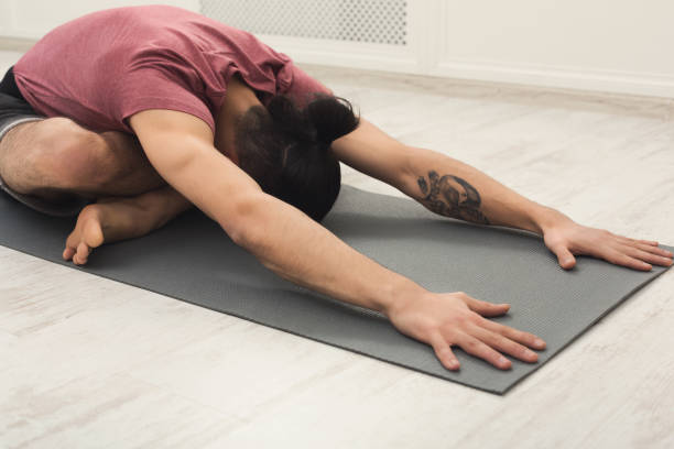 istock Young man training yoga in child's pose 939561708