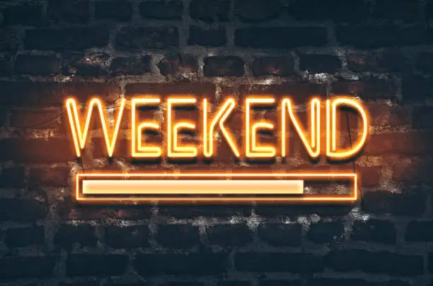 Weekend loading neon sign on dark brick wall background