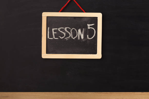 istock Word lesson 5 written on miniature chalkboard 939567250