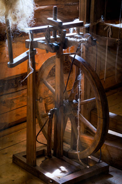 istock Old Spinning wheel  in the rays of sunshine 939568070