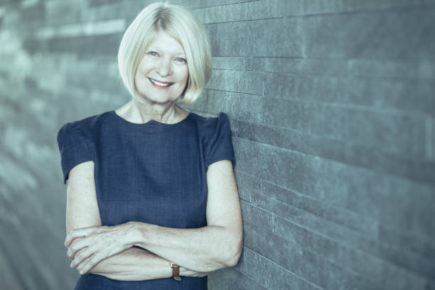 istock Happy beautiful female executive leaning on wall 939572502