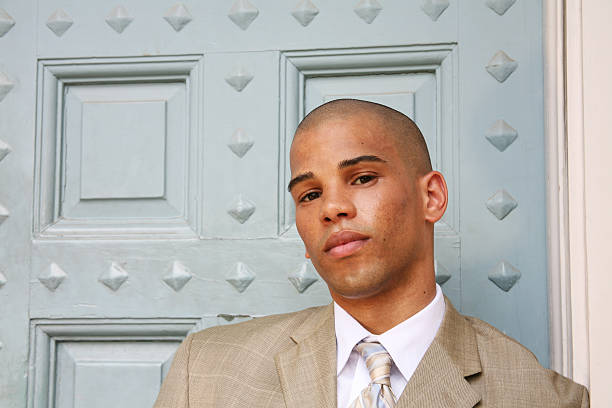 Portrait of a handsome young man in studio on black background. About 25 years old Caucasian male in suit.