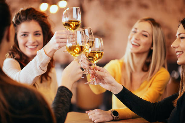 여자 친구는 바에서 와인을 마시는입니다. - champagne toast wine restaurant 뉴스 사진 이미지