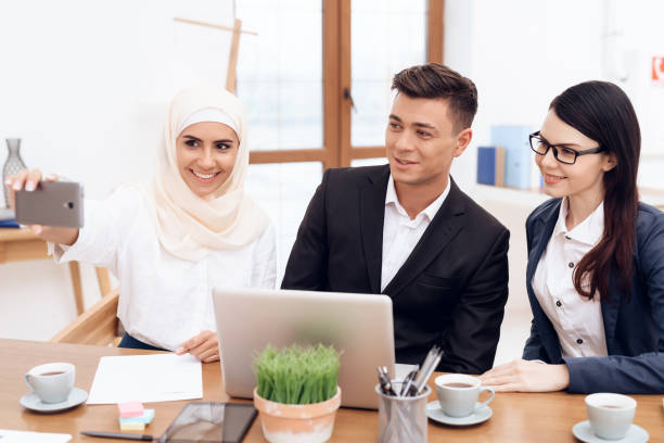 istock A woman in hijab makes selfie with her colleagues. 939577420