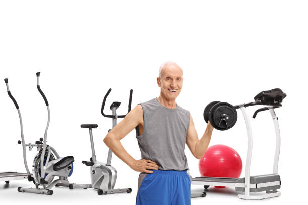 istock Elderly man with a dumbbell in front of exercise machines 939577824