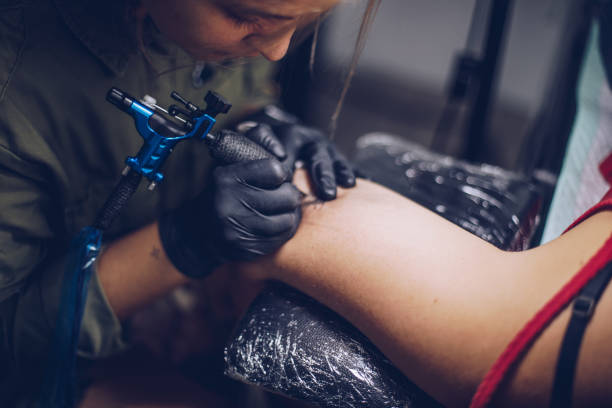 istock Woman getting tattoo on a hand 939579170