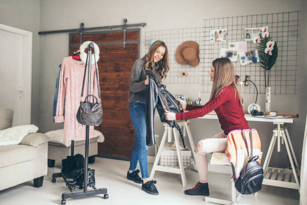 istock Two college girls try clothes 939579602