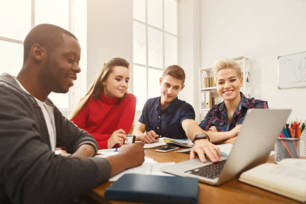 istock Group of diverse students studying at wooden table 939579736