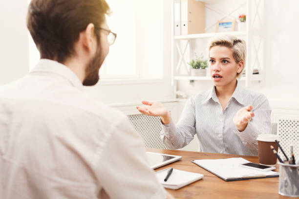 istock Couple of young colleagues working at modern office 939584124