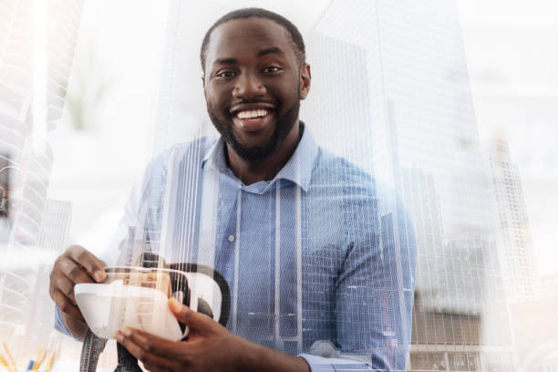 istock Smiling man holding virtual glasses and mobile phone 939584232