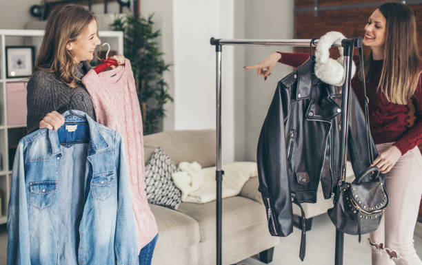 istock Two college girls try clothes 939584238