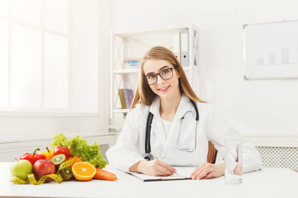 istock Nutritionist desk with fruit and measuring tape 939585062