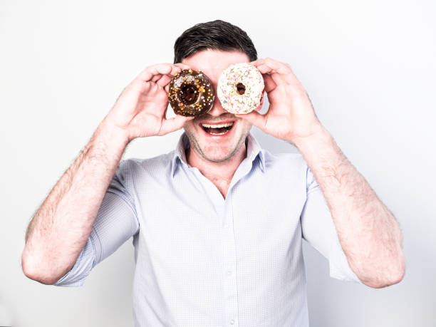 istock Funny and happy guy holding colorful donuts 939585066