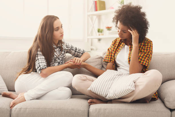 Two women talking about problems at home Two women talking about problems at home. Friendship consoling and care, unhappy girl support her girlfriend, copy space woman comforting depressed friend stock pictures, royalty-free photos & images