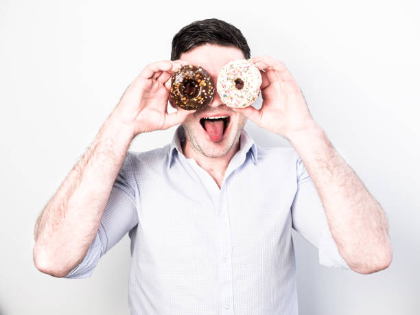 istock Funny and happy guy holding colorful donuts 939585654