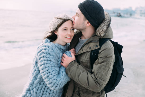 istock smiling attractive couple hugging on winter seashore 939587042