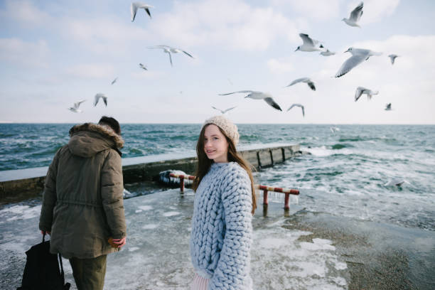 istock beautiful young couple walking on seashore in winter 939587168